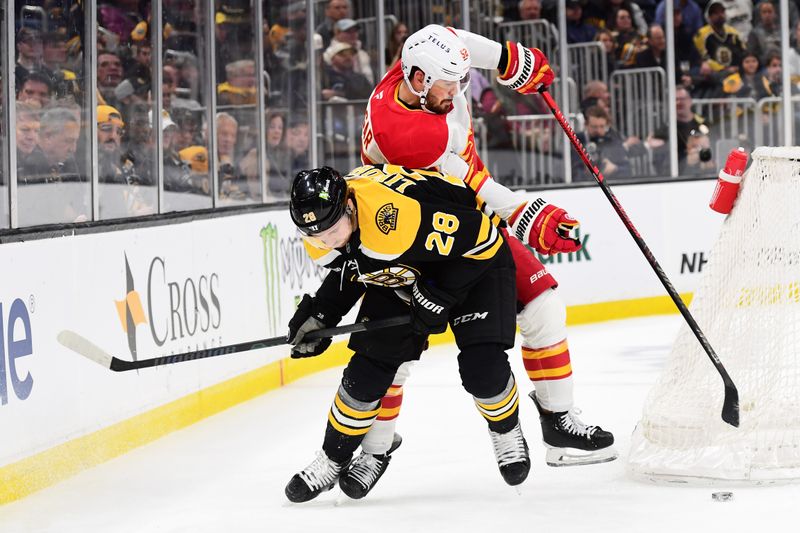 Nov 7, 2024; Boston, Massachusetts, USA;  Calgary Flames defenseman MacKenzie Weegar (52) and Boston Bruins center Elias Lindholm (28) battle for the puck during the first period at TD Garden. Mandatory Credit: Bob DeChiara-Imagn Images