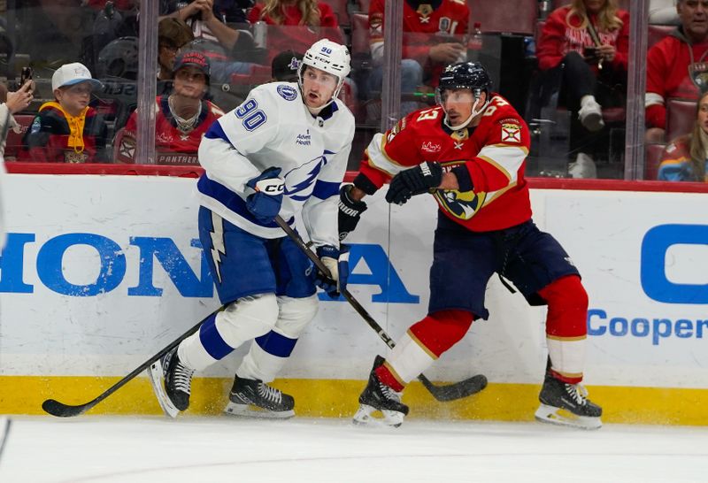 Dec 27, 2025; Sunrise, Florida, USA; Tampa Bay Lightning defenseman J.J. Moser (90) and Florida Panthers left wing Brad Marchand (63) battle during the third period at Amerant Bank Arena. Mandatory Credit: Jeff Romance-Imagn Images
