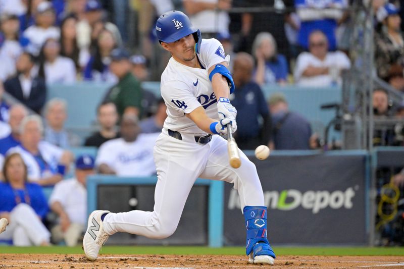 Oct 20, 2024; Los Angeles, California, USA; Los Angeles Dodgers shortstop Tommy Edman (25) hits a two RBI double in the first inning against the New York Mets during game six of the NLCS for the 2024 MLB playoffs at Dodger Stadium. Mandatory Credit: Jayne Kamin-Oncea-Imagn Images