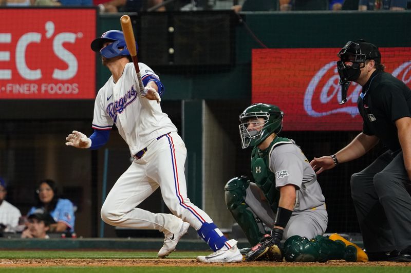 Apr 28, 2025; Arlington, Texas, USA; Texas Rangers catcher Kyle Higashioka (11) hits a double against the Athletics during the sixth inning at Globe Life Field. Mandatory Credit: Raymond Carlin III-Imagn Images