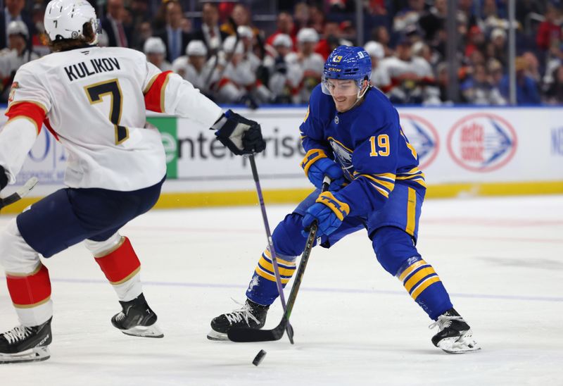 Oct 28, 2024; Buffalo, New York, USA;  Buffalo Sabres center Peyton Krebs (19) skates with the puck as Florida Panthers defenseman Dmitry Kulikov (7) defends during the second period at KeyBank Center. Mandatory Credit: Timothy T. Ludwig-Imagn Images