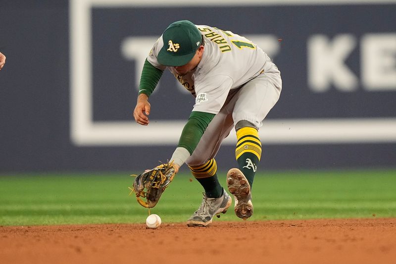 May 29, 2025; Toronto, Ontario, CAN; Athletics second baseman Luis Urias (17) can't get control of a ground ball hit by Toronto Blue Jays second baseman Michael Stefanic (not pictured) during the eighth inning at Rogers Centre. Mandatory Credit: John E. Sokolowski-Imagn Images