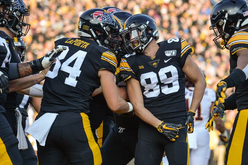 Nov 16, 2019; Iowa City, IA, USA; Iowa Hawkeyes wide receiver Nico Ragaini (89) reacts with tight end Sam LaPorta (84) and teammates after he scores on a 21 yard touchdown reception from Iowa Hawkeyes quarterback Nate Stanley (not pictured) during the first quarter against the Minnesota Golden Gophers at Kinnick Stadium. Mandatory Credit: Jeffrey Becker-USA TODAY Sports