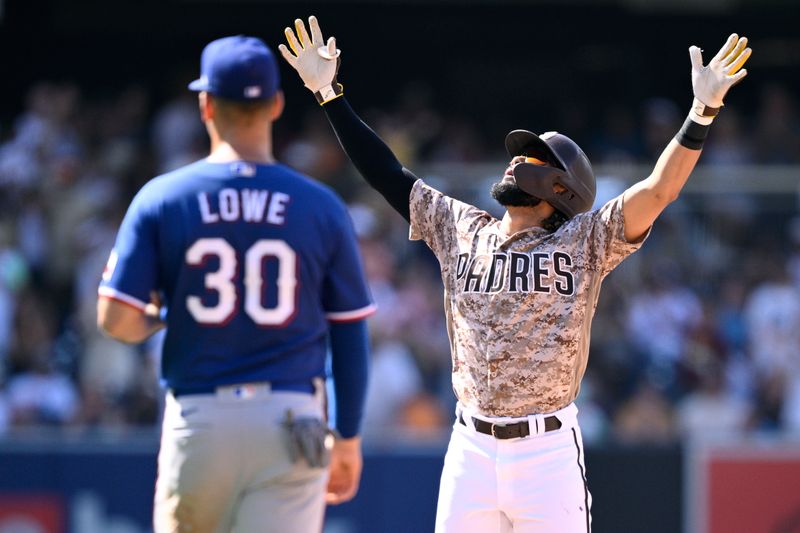 Jul 30, 2023; San Diego, California, USA; San Diego Padres right fielder Fernando Tatis (right) celebrates after hitting an RBI single and advancing to second base on an error against the Texas Rangers during the eighth inning at Petco Park. Mandatory Credit: Orlando Ramirez-USA TODAY Sports
