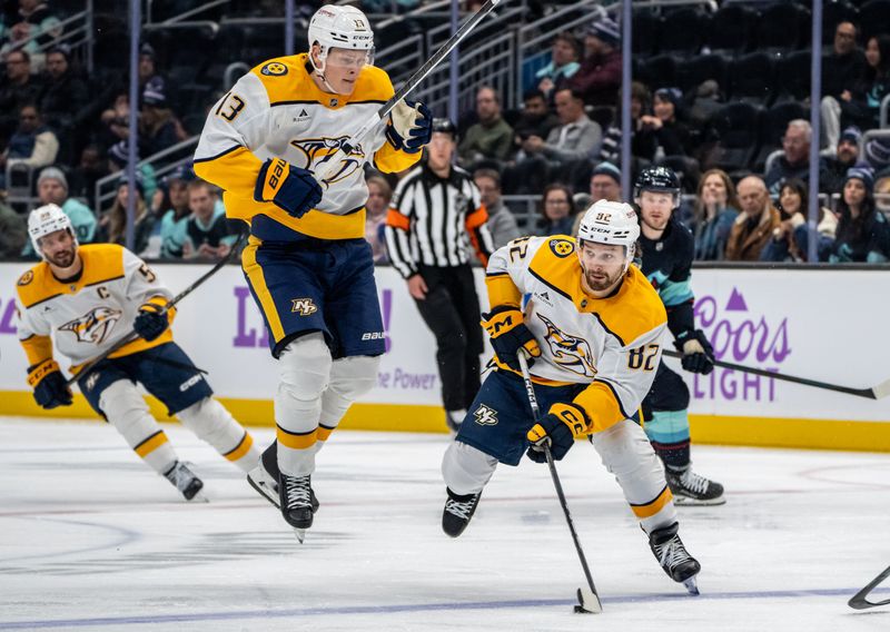 Nov 20, 2024; Seattle, Washington, USA;  Nashville Predators forward Tommy Novak (82) skates with the puck as forward Juuso Parssinen (13) jumps during the third period against the Seattle Kraken at Climate Pledge Arena. Mandatory Credit: Stephen Brashear-Imagn Images