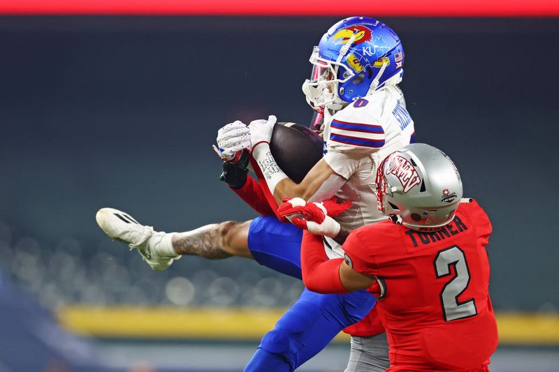 Dec 26, 2023; Phoenix, AZ, USA; Kansas Jayhawks wide receiver Quentin Skinner (0) catches a pass against UNLV Rebels defensive back Jaxen Turner (2) during the first quarter in the Guaranteed Rate Bowl at Chase Field. Mandatory Credit: Mark J. Rebilas-USA TODAY Sports