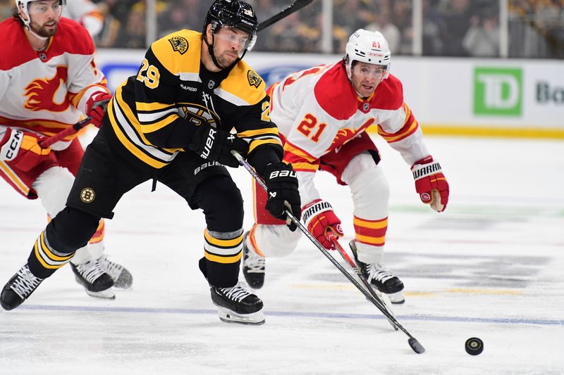 Nov 7, 2024; Boston, Massachusetts, USA;  Boston Bruins defenseman Parker Wotherspoon (29) reaches for the puck ahead of Calgary Flames center Kevin Rooney (21) during the second period at TD Garden. Mandatory Credit: Bob DeChiara-Imagn Images