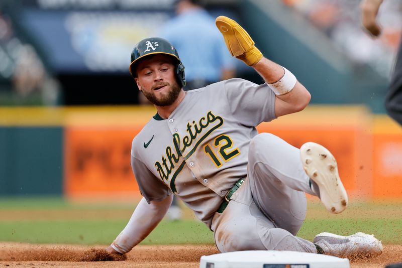 Jun 26, 2025; Detroit, Michigan, USA;  Athletics third base Max Schuemann (12) slides in safe at third in the third inning against the Detroit Tigers at Comerica Park. Mandatory Credit: Rick Osentoski-Imagn Images
