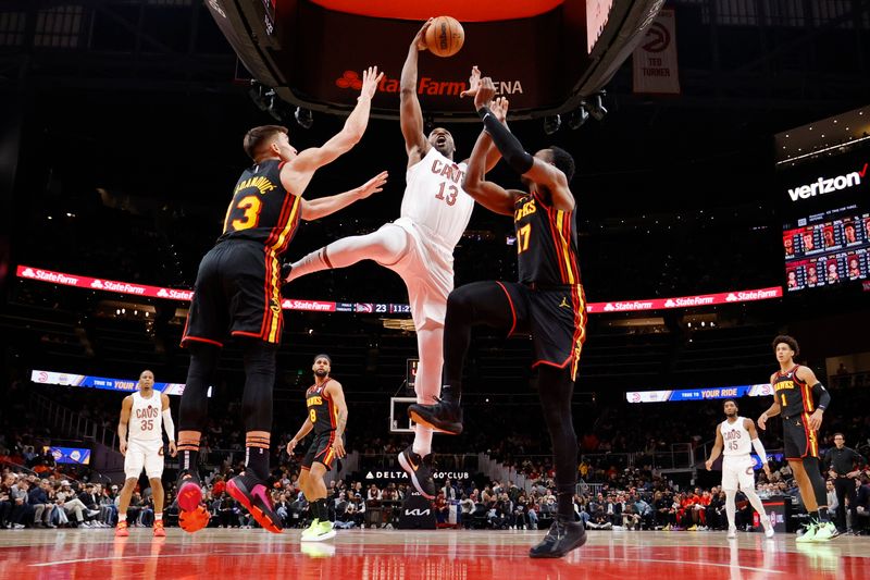 ATLANTA, GEORGIA - JANUARY 20: Tristan Thompson #13 of the Cleveland Cavaliers shoots between Bogdan Bogdanovic #13 of the Atlanta Hawks and Onyeka Okongwu #17 during the first half at State Farm Arena on January 20, 2024 in Atlanta, Georgia. NOTE TO USER: User expressly acknowledges and agrees that, by downloading and or using this photograph, User is consenting to the terms and conditions of the Getty Images License Agreement. (Photo by Alex Slitz/Getty Images)