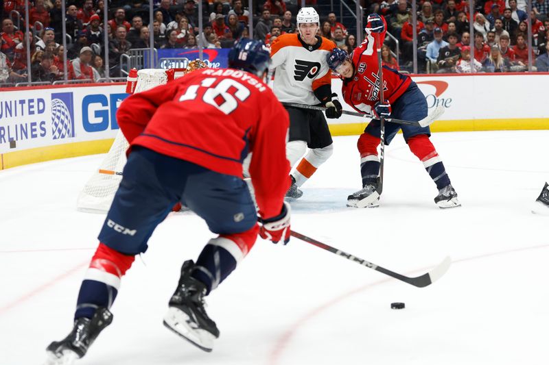 Oct 23, 2024; Washington, District of Columbia, USA; Washington Capitals right wing Taylor Raddysh (16) prepares to pass the puck to Capitals center Nic Dowd (26) as Philadelphia Flyers defenseman Egor Zamula (5) defends in the third period at Capital One Arena. Mandatory Credit: Geoff Burke-Imagn Images