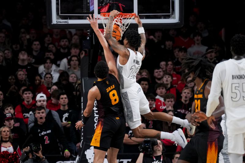 Jan 18, 2025; Cincinnati, Ohio, USA;  Cincinnati Bearcats forward Dillon Mitchell (23) dunks the ball over Arizona State Sun Devils forward Basheer Jihad (8) in the second half at Fifth Third Arena. Mandatory Credit: Aaron Doster-Imagn Images