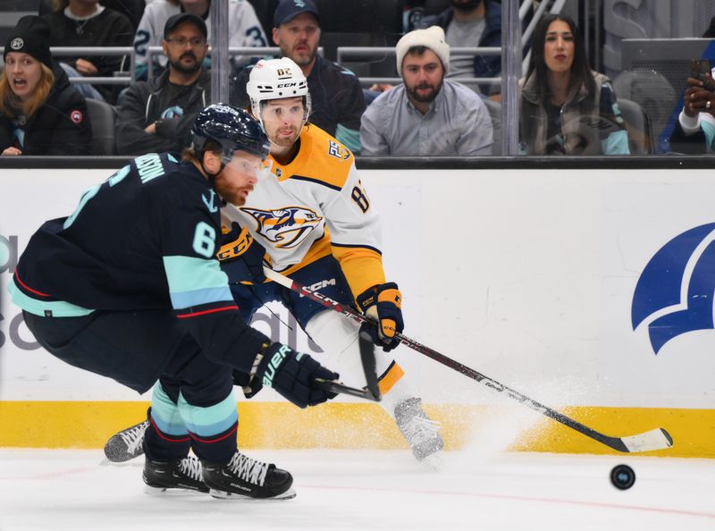 Nov 2, 2023; Seattle, Washington, USA; Nashville Predators center Tommy Novak (82) passes the puck past Seattle Kraken defenseman Adam Larsson (6) during the second period at Climate Pledge Arena. Mandatory Credit: Steven Bisig-USA TODAY Sports