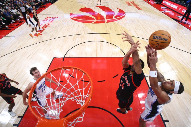 TORONTO, CANADA - MARCH 15:  Paolo Banchero #5 of the Orlando Magic and Jontay Porter #34 of the Toronto Raptors battle for a rebound on March 15, 2024 at the Scotiabank Arena in Toronto, Ontario, Canada.  NOTE TO USER: User expressly acknowledges and agrees that, by downloading and or using this Photograph, user is consenting to the terms and conditions of the Getty Images License Agreement.  Mandatory Copyright Notice: Copyright 2024 NBAE (Photo by Vaughn Ridley/NBAE via Getty Images)