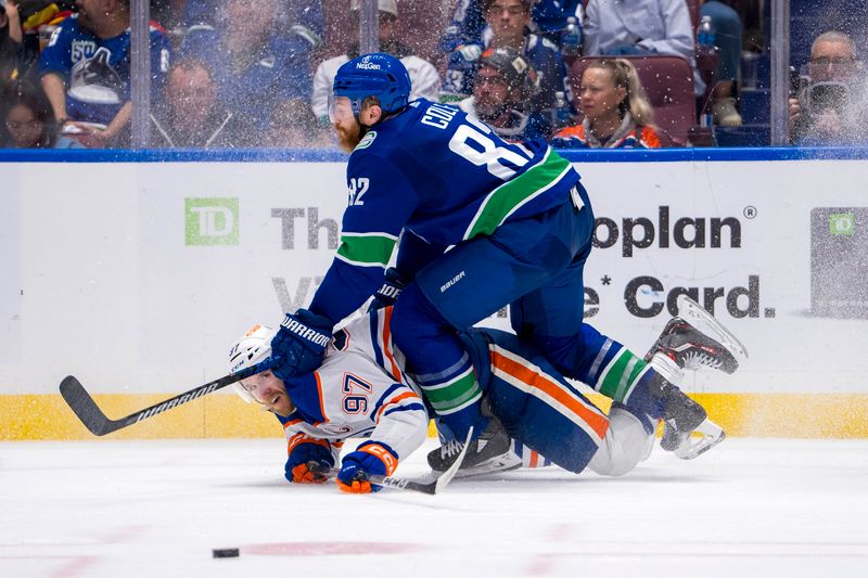 May 20, 2024; Vancouver, British Columbia, CAN; Vancouver Canucks defenseman Ian Cole (82) checks Edmonton Oilers forward Connor McDavid (97) during the second period in game seven of the second round of the 2024 Stanley Cup Playoffs at Rogers Arena. Mandatory Credit: Bob Frid-USA TODAY Sports