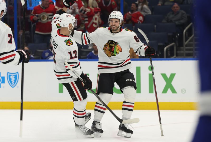 Jan 28, 2025; Tampa, Florida, USA; Chicago Blackhawks left wing Landon Slaggert (84) celebrates with left wing Nick Foligno (17) after he scored a goal against the Tampa Bay Lightning during the second period at Amalie Arena. Mandatory Credit: Kim Klement Neitzel-Imagn Images