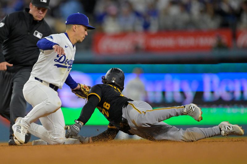 Apr 25, 2025; Los Angeles, California, USA;  Los Angeles Dodgers second baseman Tommy Edman (25) tags Pittsburgh Pirates second baseman Adam Frazier (26) on a stolen base attempt in the sixth at Dodger Stadium. Mandatory Credit: Jayne Kamin-Oncea-Imagn Images