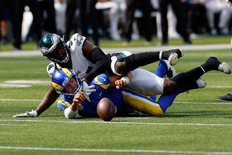 Los Angeles Rams quarterback Matthew Stafford, below, loses the ball after being tackled by Philadelphia Eagles defensive end Josh Sweat during the first half of an NFL football game Sunday, Oct. 8, 2023, in Inglewood, Calif. (AP Photo/Kevork Djansezian)