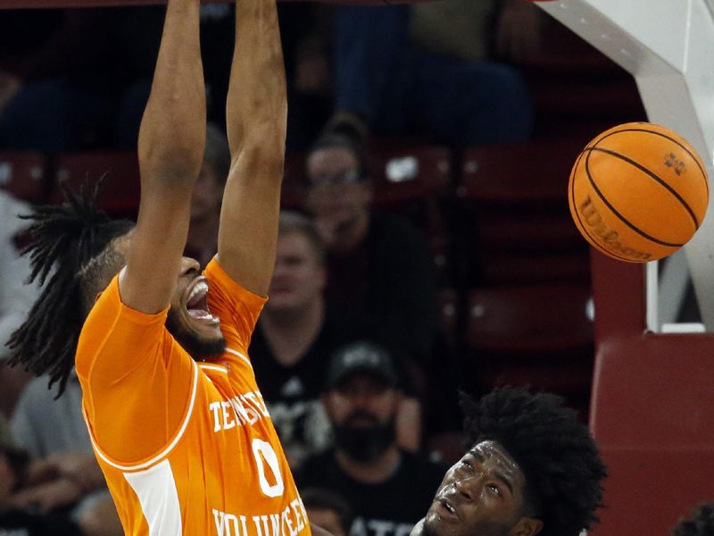 Jan 17, 2023; Starkville, Mississippi, USA; Tennessee Volunteers forward Jonas Aidoo (0) dunks over Mississippi State Bulldogs guard Cameron Matthews (4) during the second half at Humphrey Coliseum. Mandatory Credit: Petre Thomas-USA TODAY Sports