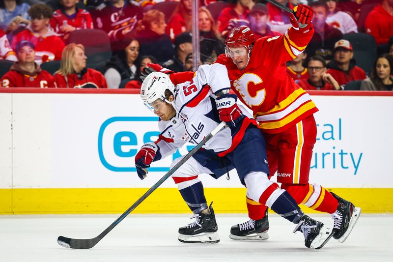 Jan 28, 2025; Calgary, Alberta, CAN; Washington Capitals center Ethen Frank (53) and Calgary Flames defenseman Tyson Barrie (8) battles for the puck during the first period at Scotiabank Saddledome. Mandatory Credit: Sergei Belski-Imagn Images