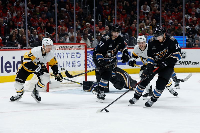 Jan 18, 2025; Washington, District of Columbia, USA; Washington Capitals center Nic Dowd (26) skates with the puck past Pittsburgh Penguins left wing Michael Bunting (8) and Penguins left wing Anthony Beauvillier (72) in the second period at Capital One Arena. Mandatory Credit: Geoff Burke-Imagn Images