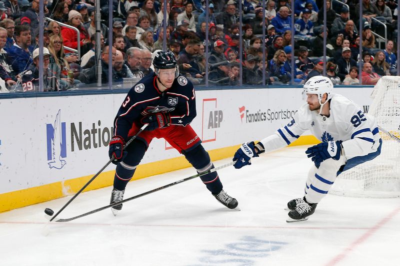 Oct 29, 2025; Columbus, Ohio, USA; Toronto Maple Leafs defenseman Oliver Ekman-Larsson (95) and Columbus Blue Jackets center Charlie Coyle (3) battle for the puck during the second period at Nationwide Arena. Mandatory Credit: Russell LaBounty-Imagn Images
