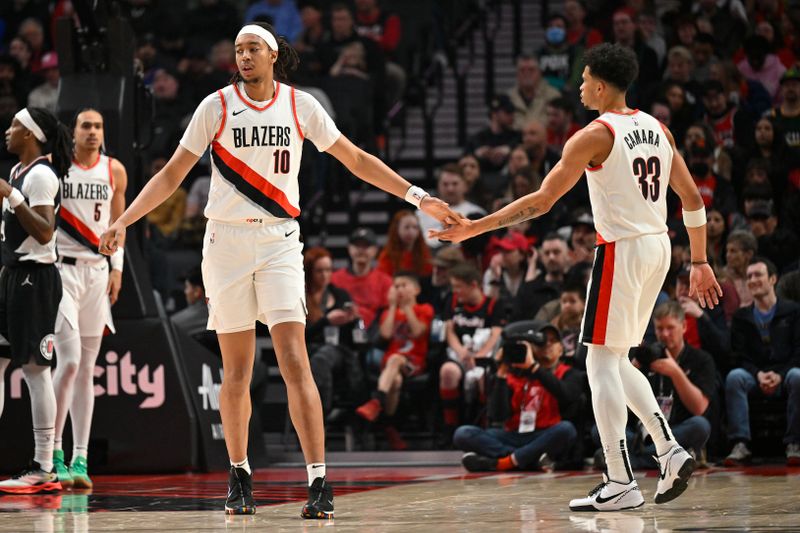 PORTLAND, OREGON - MARCH 22: Moses Brown #10 of the Portland Trail Blazers and Toumani Camara #33 shake hands during the first quarter of the game against the LA Clippers at the Moda Center on March 22, 2024 in Portland, Oregon. The LA Clippers won 125-117. NOTE TO USER: User expressly acknowledges and agrees that, by downloading and or using this photograph, User is consenting to the terms and conditions of the Getty Images License Agreement. (Photo by Alika Jenner/Getty Images)