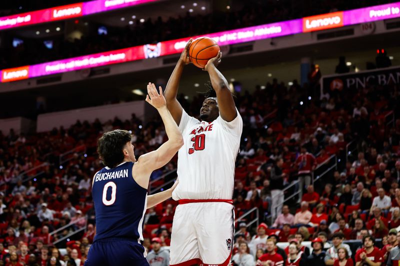 Jan 6, 2024; Raleigh, North Carolina, USA; North Carolina State Wolfpack guard Alex Nunnally (20) shoots a three pointer guarded by Virginia Cavaliers forward Blake Buchanan (0) during the first half at PNC Arena. Mandatory Credit: Jaylynn Nash-USA TODAY Sports