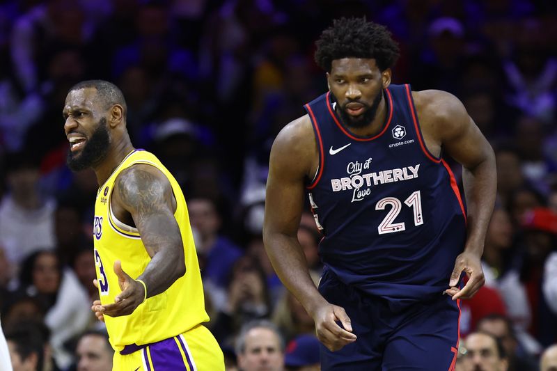 PHILADELPHIA, PENNSYLVANIA - NOVEMBER 27: LeBron James #23 of the Los Angeles Lakers reacts behind Joel Embiid #21 of the Philadelphia 76ers during the third quarter at the Wells Fargo Center on November 27, 2023 in Philadelphia, Pennsylvania. NOTE TO USER: User expressly acknowledges and agrees that, by downloading and or using this photograph, User is consenting to the terms and conditions of the Getty Images License Agreement. (Photo by Tim Nwachukwu/Getty Images)