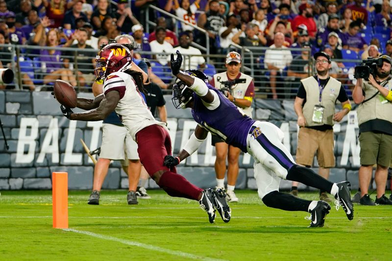 Washington Commanders wide receiver Marken Michel, left, is unable to hold onto a pass attempt as he is pressured by Baltimore Ravens cornerback Brandon Stephens in the first half of a preseason NFL football game, Saturday, Aug. 27, 2022, in Baltimore. (AP Photo/Julio Cortez)