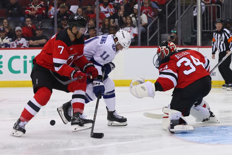 Oct 22, 2024; Newark, New Jersey, USA; New Jersey Devils defenseman Dougie Hamilton (7) and Tampa Bay Lightning center Luke Glendening (11) battle for the puck during the first period at Prudential Center. Mandatory Credit: Ed Mulholland-Imagn Images