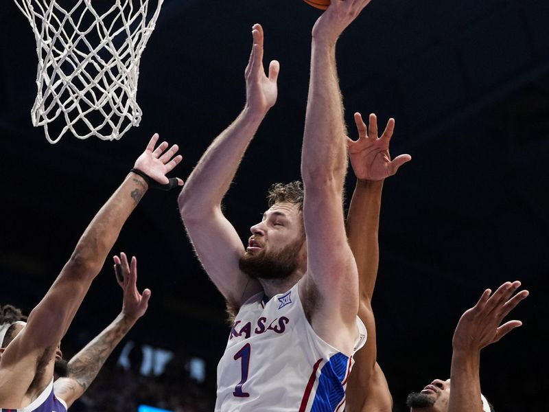 Jan 6, 2024; Lawrence, Kansas, USA; Kansas Jayhawks center Hunter Dickinson (1) shoots against TCU Horned Frogs guard Micah Peavy (0) and forward Xavier Cork (12) during the second half at Allen Fieldhouse. Mandatory Credit: Jay Biggerstaff-USA TODAY Sports