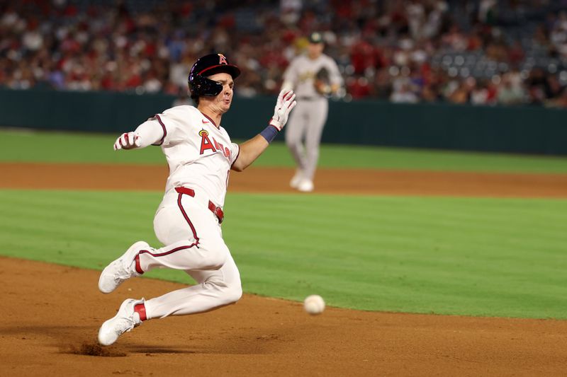 Jul 25, 2024; Anaheim, California, USA;  Los Angeles Angels center fielder Mickey Moniak (16) slides into third base on a double during the seventh inning against the Oakland Athletics at Angel Stadium. Mandatory Credit: Kiyoshi Mio-USA TODAY Sports