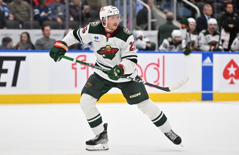 Oct 14, 2023; Toronto, Ontario, CAN;  Minnesota Wild defenseman Jonas Brodin (25) pursues the play against the Toronto Maple Leafs in the third period at Scotiabank Arena. Mandatory Credit: Dan Hamilton-USA TODAY Sports