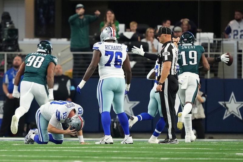 Dallas Cowboys quarterback Cooper Rush (10) recovers from fumbling the ball as the Philadelphia Eagles celebrate recovering the fumble in the first half of an NFL football game in Arlington, Texas, Sunday, Nov. 10, 2024. (AP Photo/Jeffrey McWhorter)