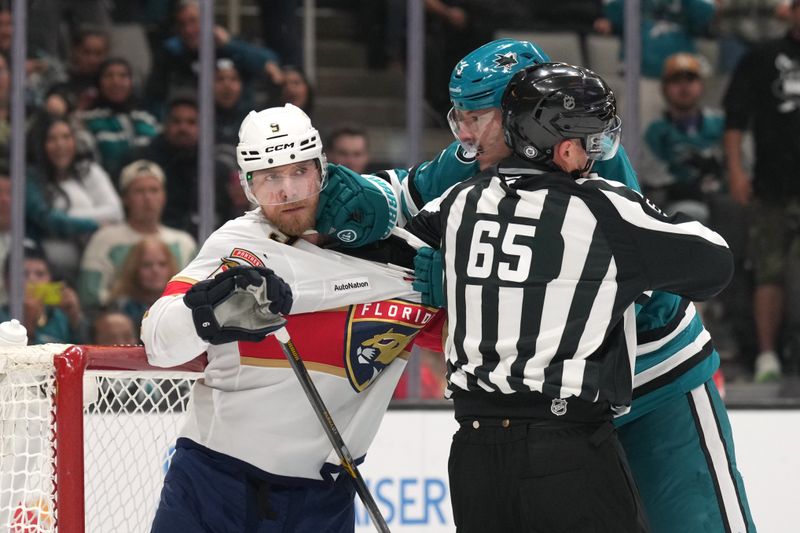 Nov 8, 2025; San Jose, California, USA; Linesman Tommy Hughes (65) attempts to break up an altercation between Florida Panthers center Sam Bennett (9) and San Jose Sharks defenseman Vincent Desharnais (right back) at the end of the first period at SAP Center at San Jose. Mandatory Credit: Darren Yamashita-Imagn Images