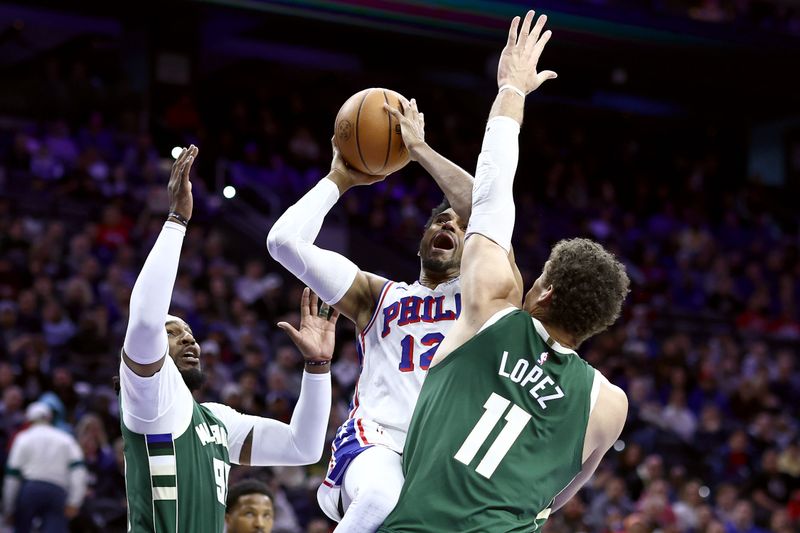 PHILADELPHIA, PENNSYLVANIA - FEBRUARY 25: Tobias Harris #12 of the Philadelphia 76ers shoots a lay up between Jae Crowder #99 and Brook Lopez #11 of the Milwaukee Bucks during the second quarter at the Wells Fargo Center on February 25, 2024 in Philadelphia, Pennsylvania. (Photo by Tim Nwachukwu/Getty Images)