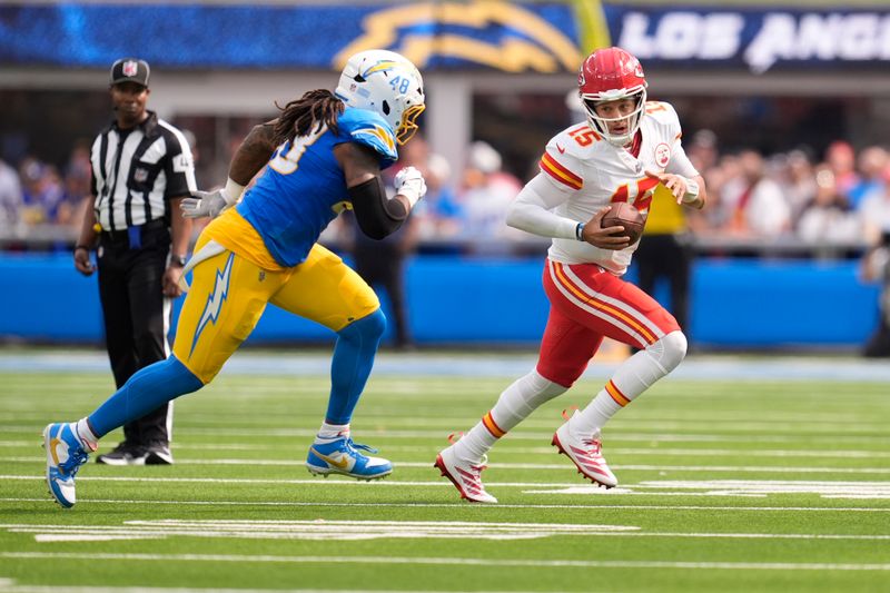 Kansas City Chiefs quarterback Patrick Mahomes (15) scrambles as Los Angeles Chargers outside linebacker Bud Dupree (48) defends during the first half of an NFL football game Sunday, Sept. 29, 2024, in Inglewood, Calif. (AP Photo/Marcio Jose Sanchez)