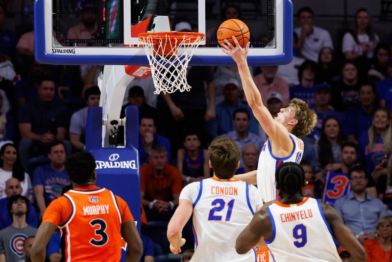 Jan 24, 2026; Gainesville, Florida, USA; Florida Gators forward Thomas Haugh (10) makes a layup over Auburn Tigers forward Filip Jovic (38) during the first half at Exactech Arena at the Stephen C. O'Connell Center. Mandatory Credit: Matt Pendleton-Imagn Images