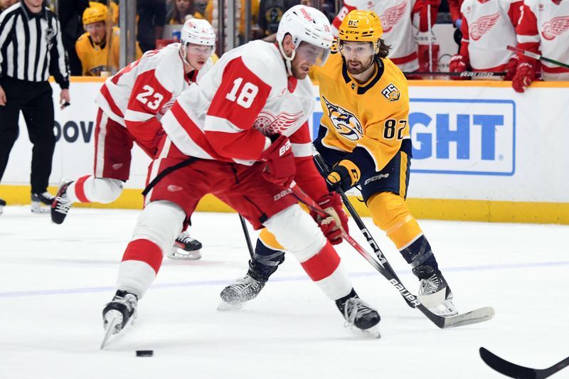 Mar 23, 2024; Nashville, Tennessee, USA; Nashville Predators center Tommy Novak (82) passes the puck between the legs of Detroit Red Wings center Andrew Copp (18) during the first period at Bridgestone Arena. Mandatory Credit: Christopher Hanewinckel-USA TODAY Sports