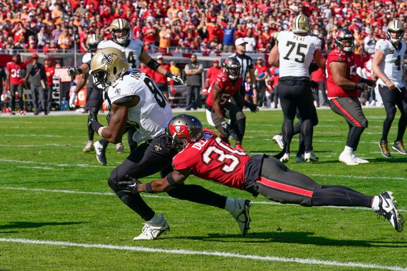 New Orleans Saints tight end Juwan Johnson scores on a touchdown reception against Tampa Bay Buccaneers cornerback Dee Delaney (30) in the first half of an NFL football game in Tampa, Fla., Sunday, Dec. 31, 2023. (AP Photo/Chris O'Meara)