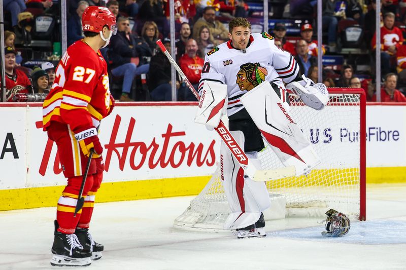 Nov 7, 2025; Calgary, Alberta, CAN; Chicago Blackhawks goaltender Spencer Knight (30) helmet come off during the second period against the Calgary Flames at Scotiabank Saddledome. Mandatory Credit: Sergei Belski-Imagn Images