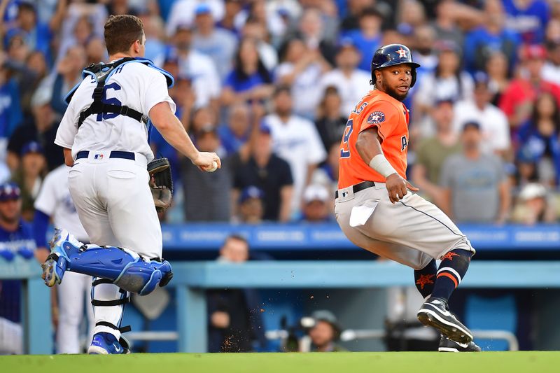 Jun 25, 2023; Los Angeles, California, USA; Houston Astros second baseman Mauricio Dubon (14) scores a run against Los Angeles Dodgers catcher Will Smith (16) during the eleventh inning at Dodger Stadium. Mandatory Credit: Gary A. Vasquez-USA TODAY Sports