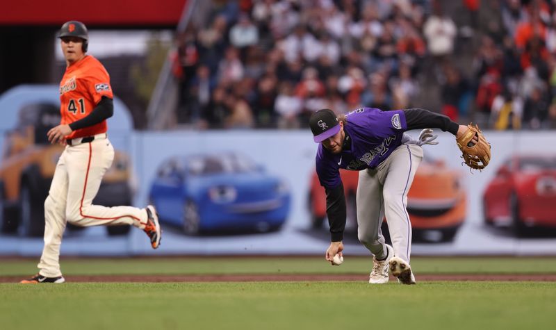May 2, 2025; San Francisco, California, USA; Colorado Rockies third baseman Ryan McMahon (24) gathers the ball as San Francisco Giants designated hitter Wilmer Flores (41) runs to third base during the second inning at Oracle Park. Mandatory Credit: Kelley L Cox-Imagn Images