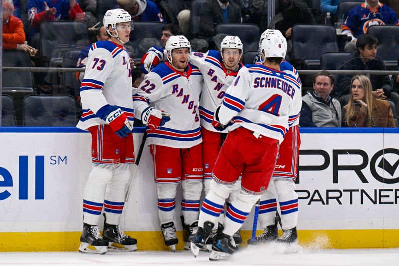 Feb 25, 2025; Elmont, New York, USA;  New York Rangers center Jonny Brodzinski (22) celebrates a goal against the New York Islanders with center Matt Rempe (73), defenseman Braden Schneider (4) and defenseman Urho Vaakanainen (18) during the first period at UBS Arena. Mandatory Credit: Dennis Schneidler-Imagn Images