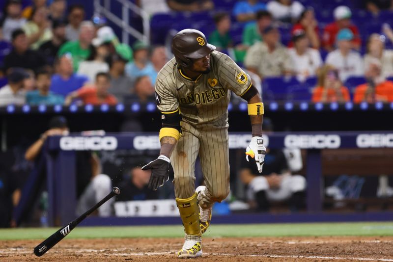 Aug 11, 2024; Miami, Florida, USA; San Diego Padres first baseman Luis Arraez (4) hits a single against the Miami Marlins during the eighth inning at loanDepot Park. Mandatory Credit: Sam Navarro-USA TODAY Sports