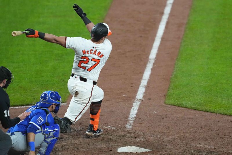 Apr 3, 2024; Baltimore, Maryland, USA; Baltimore Orioles catcher James McCann (27) delivers the game winning hit scoring two runs in the ninth inning against the Kansas City Royals at Oriole Park at Camden Yards. Mandatory Credit: Mitch Stringer-USA TODAY Sports