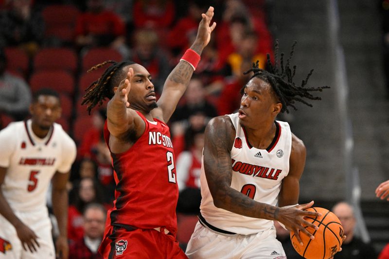 Jan 13, 2024; Louisville, Kentucky, USA;  Louisville Cardinals guard Mike James (0) controls the ball against North Carolina State Wolfpack guard Kam Woods (2) during the first half at KFC Yum! Center. Mandatory Credit: Jamie Rhodes-USA TODAY Sports