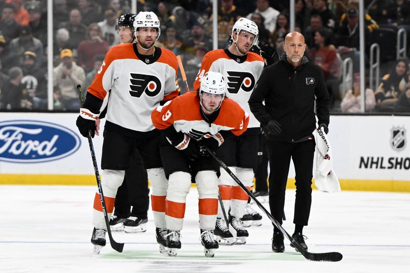 Oct 29, 2024; Boston, Massachusetts, USA; Philadelphia Flyers defenseman Jamie Drysdale (9) is helped off the ice during the second period of a game against the Boston Bruins at TD Garden. Mandatory Credit: Brian Fluharty-Imagn Images