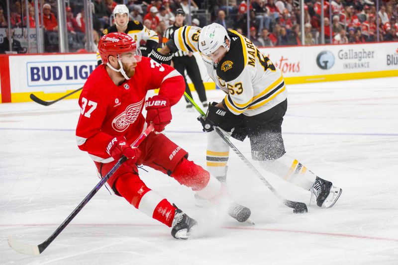 Nov 23, 2024; Detroit, Michigan, USA; Boston Bruins left wing Brad Marchand (63) handles the puck against Detroit Red Wings left wing J.T. Compher (37) during the first period at Little Caesars Arena. Mandatory Credit: Brian Bradshaw Sevald-Imagn Images