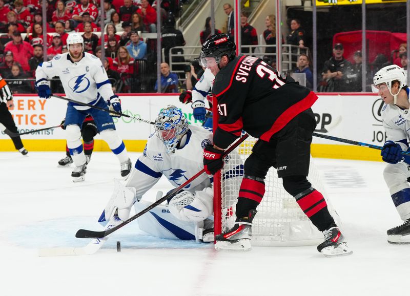 Oct 11, 2024; Raleigh, North Carolina, USA;  Tampa Bay Lightning goaltender Andrei Vasilevskiy (88) stops the shot attempt by Carolina Hurricanes right wing Andrei Svechnikov (37) during the first period at PNC Arena. Mandatory Credit: James Guillory-Imagn Images